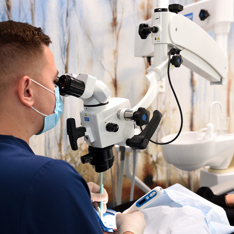Endodoncja mikroskopowa Lek. dent. Kacper Wolszczak podczas leczenia kanałowego pod mikroskopem